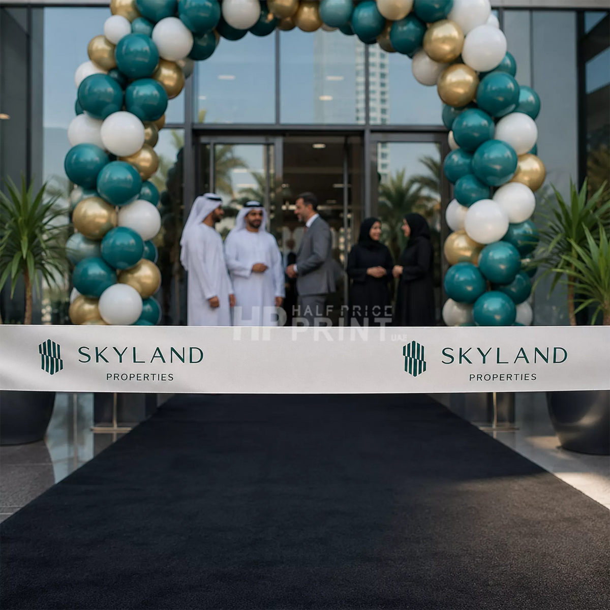 Group of people standing under a balloon arch with 'Skyland Properties' branding and ceremony ribbon