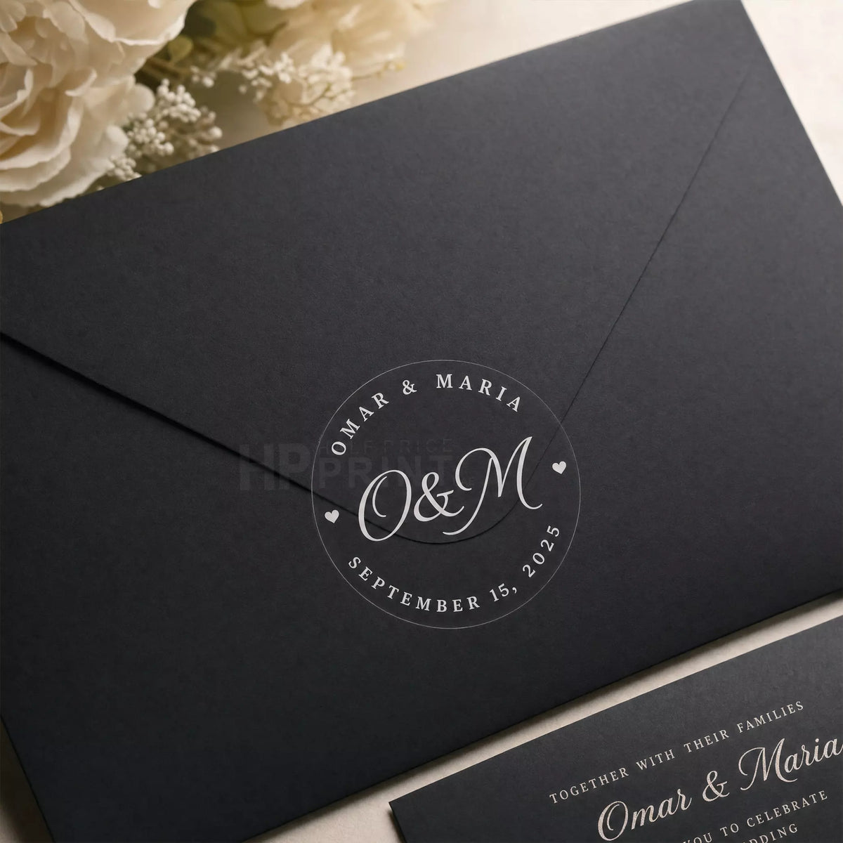 Black envelope with a personalized white inked sticker and wedding invitation text.