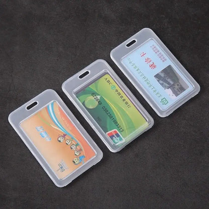 Three clear plastic ID card holders displaying different cards, laid out side by side on a dark background.