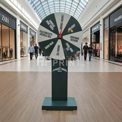 Large spinner toy in a shopping mall with various options on its sections.