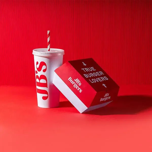 Red and white burger box and drink cup with JB's Burgers branding on red background