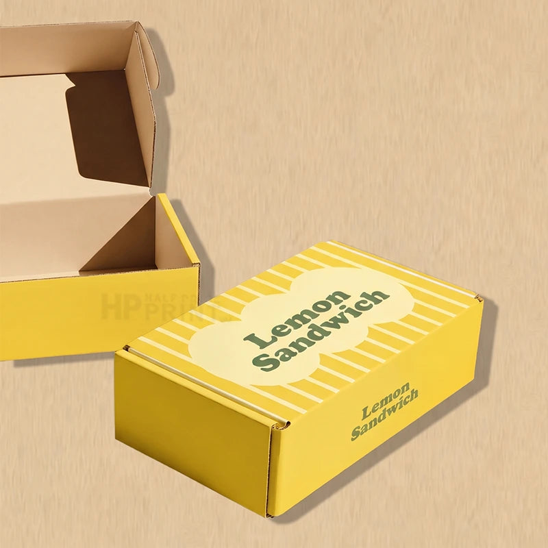 A yellow cardboard product box labeled 'Lemon Sandwich' with a matching open box behind it, shown on a beige textured background.