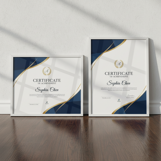 Two framed certificates of achievement on a wooden surface with a white wall background.