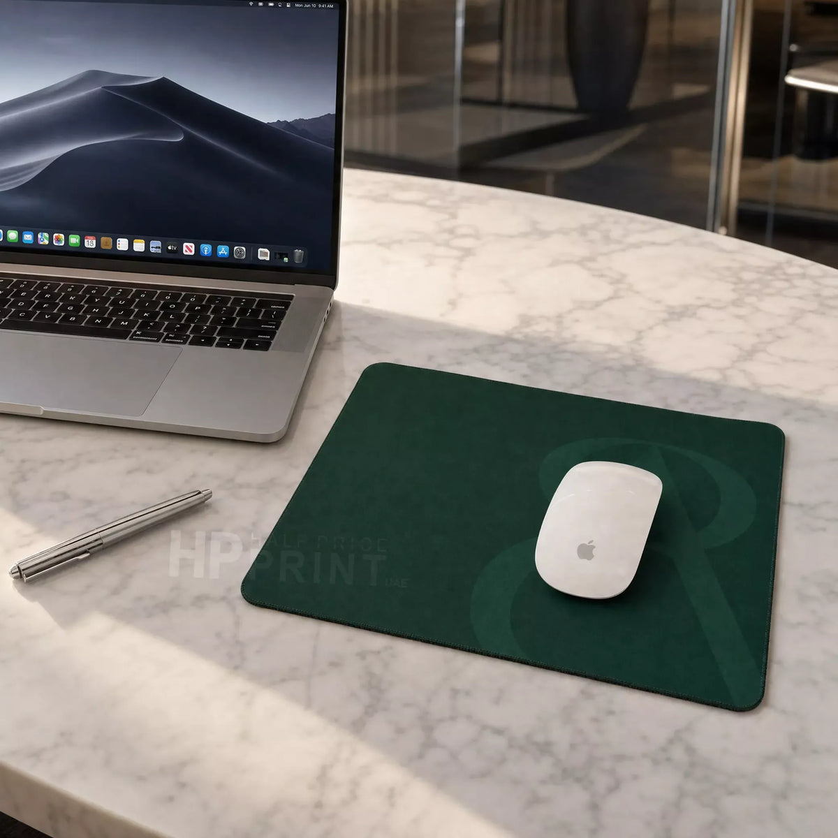 Laptop on a marble surface with a green mouse pad and white mouse
