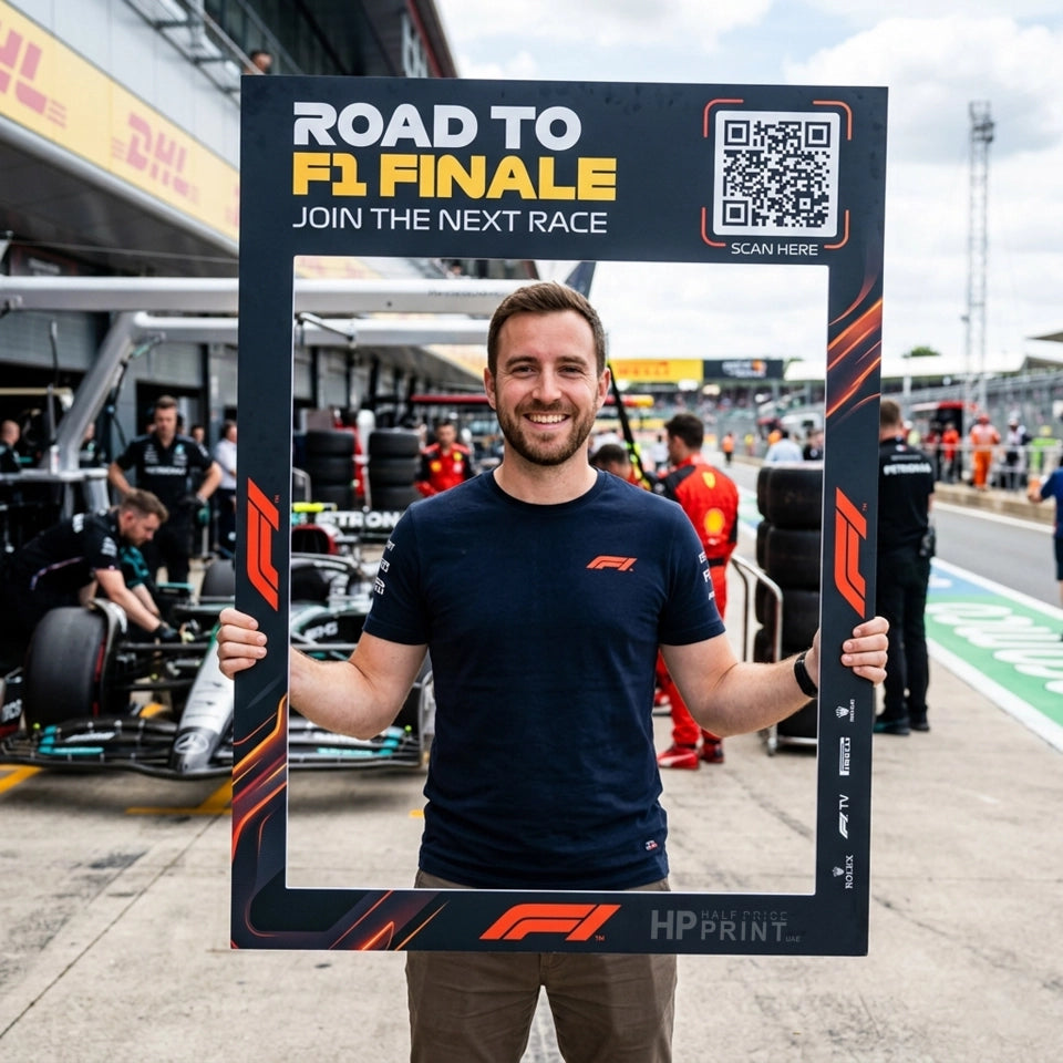 Person holding a photo frame with F1 branding at a race track.