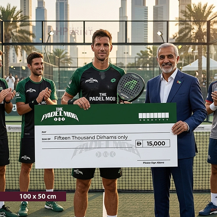 Group of people on a tennis court holding a large cheque, with a man in a suit standing next to them.