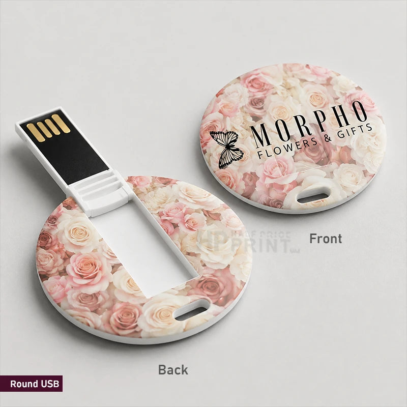 A round USB flash drive shown in both front and back views on a light gray background. The drive has a floral print with pink, peach, and cream roses, and the back side features a black magnetic USB connector.