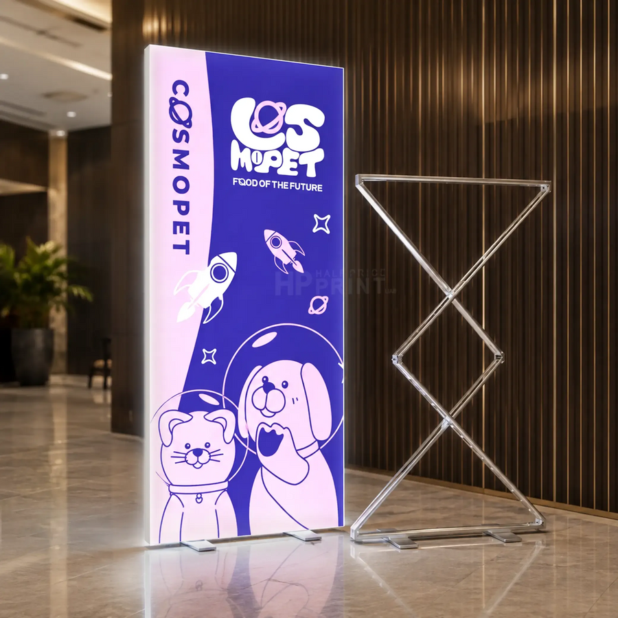 A custom LED neon-style vertical snapfold standee for 'CosmoPet Food of the Future' displayed next to a clear acrylic X-frame easel in a modern lobby setting.