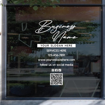 Glass storefront window featuring a business name vinyl sticker with slogan, services text, phone number, website, social media icons, and a QR code, shown from outside with street reflections.
